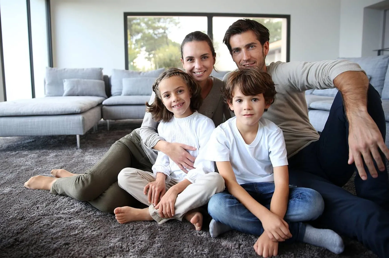 A family sitting on soft carpet floors